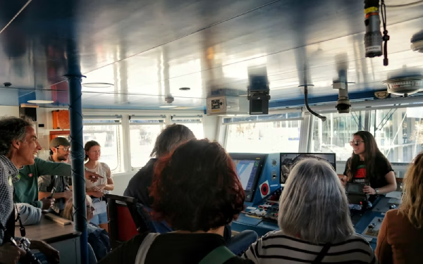 Passengers looking at screens inside a train or boat cabin
